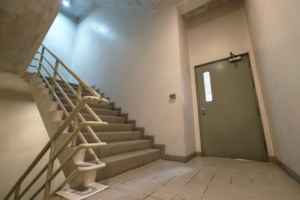 Stairwell with exit door in corridor. 