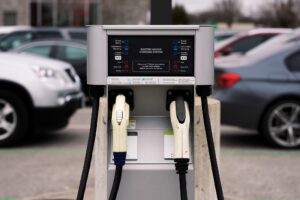 Electric vehicle charging station with parking lot background.